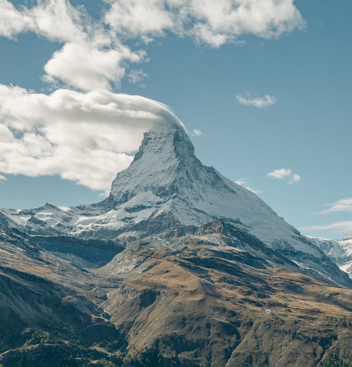 journey-01 Stunning view of the Matterhorn in Zermatt, Switzerland with a cloud-capped peak on a clear day.